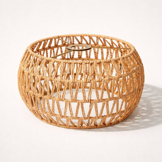 Abat-jour lampadaire en corde naturelle tressée, forme arrondie ajourée, style bohème et lumière douce.