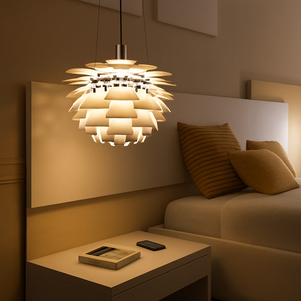 Suspension design en métal allumée au-dessus d’une table de chevet, diffusant une lumière chaude dans une chambre moderne et cosy.