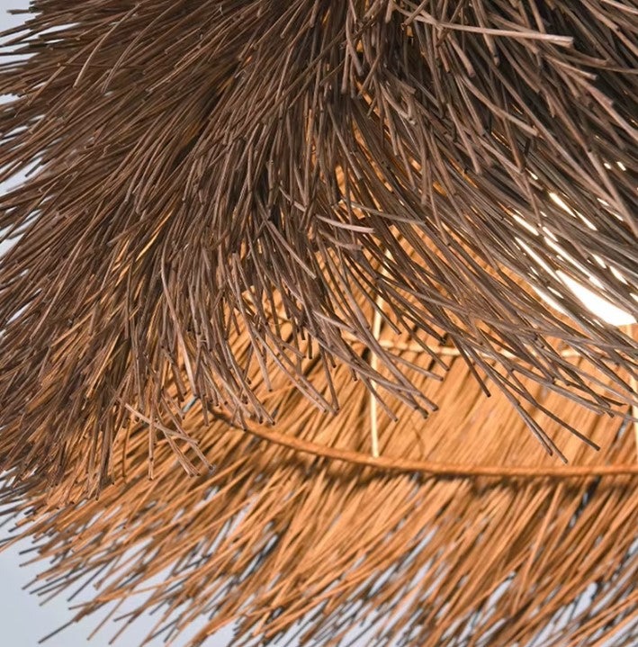 Détail d’un abat-jour suspension en rotin, texture naturelle et lumière tamisée chaleureuse.