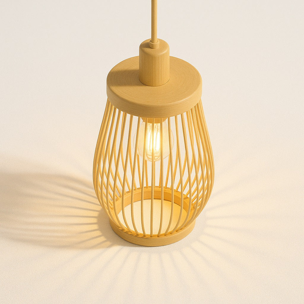 Suspension en rotin Ona vue du dessus, forme goutte ajourée, diffusant une lumière chaude avec ombres graphiques au sol.