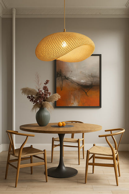 Lampe suspension en rotin ondulé suspendue au-dessus d’une table ronde bois, ambiance design douce et contemporaine.