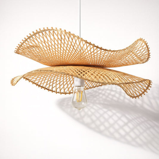 Abat-jour suspension rotin sculptural sur fond blanc, ombre ajourée et design moderne.