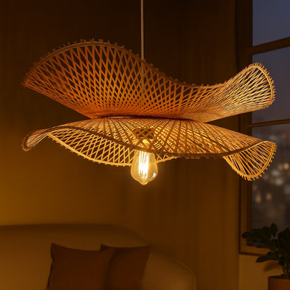 Abat-jour suspension rotin allumé la nuit, tressage sculptural et lumière chaleureuse.