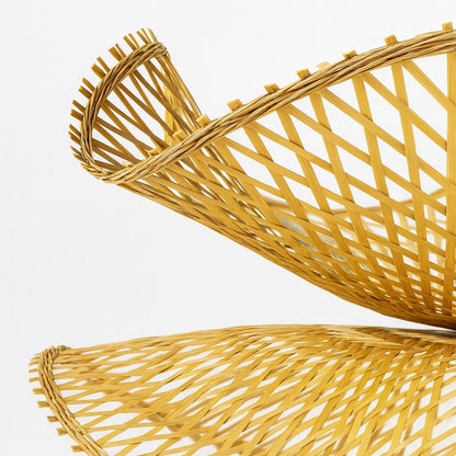Gros plan sur le tressage d’un abat-jour suspension rotin, forme ondulée et finitions artisanales.