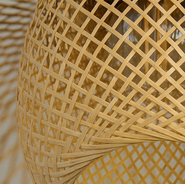 Abat-jour suspension en rotin tressé, forme organique et lumière chaleureuse pour intérieur moderne.
