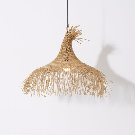 Suspension en rotin naturel Zaraya, abat-jour tressé à la forme libre avec lumière douce et ombre graphique sur mur blanc.