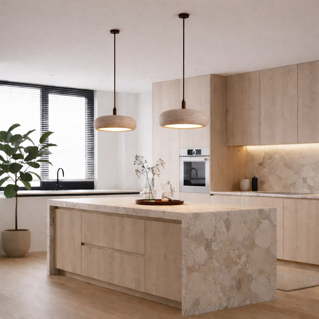Un abat-jour en travertin à l’esthétique aérienne qui mêle élégance discrète et chaleur lumineuse, dans une belle cuisine.