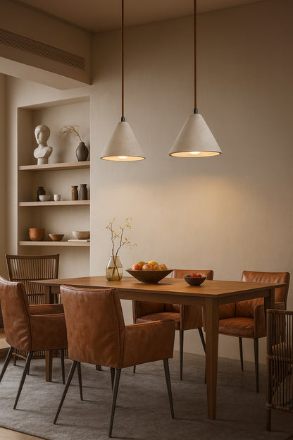 Suspensions coniques en travertin éclairant une salle à manger contemporaine avec table en bois et chaises cuir dans un décor beige.