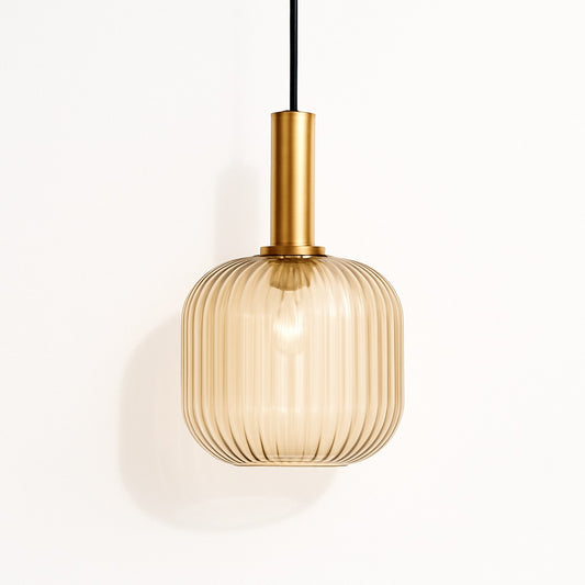 Suspension en verre nervuré ambré avec douille dorée, forme arrondie, lumière douce projetée au mur blanc.