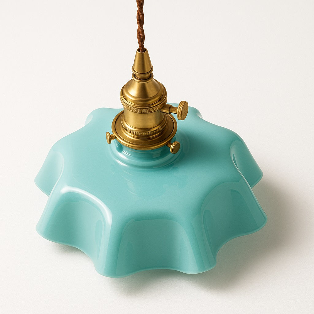 Vue de dessus de la suspension Avara en verre turquoise et laiton, reflet lumineux et lignes ondulées raffinées.