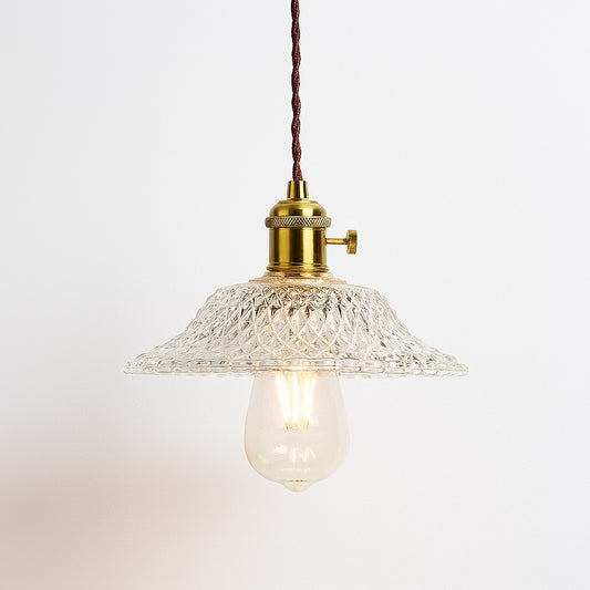 Suspension en verre transparent Bullina avec abat-jour ondulé, douille laiton doré et ampoule apparente.