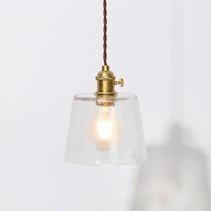 Suspension en verre transparent texturé avec douille laiton doré et cordon textile marron, style vintage.