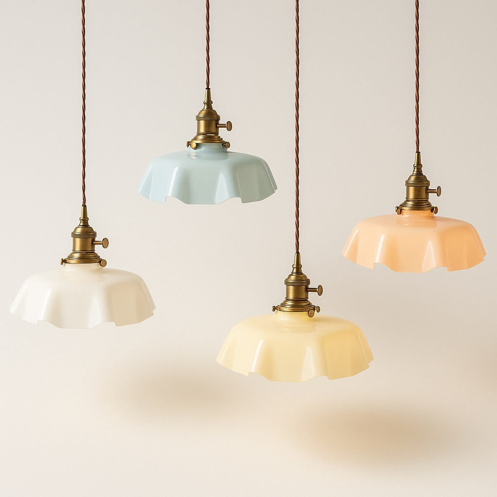 Quatre suspensions vintage en verre coloré avec cordons torsadés et douilles en laiton, sur fond blanc avec ombre douce.