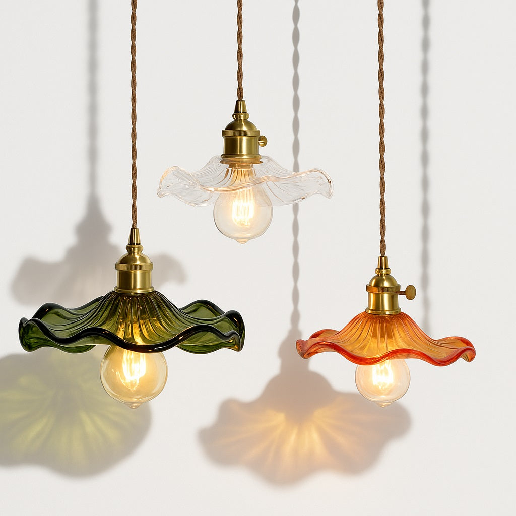 Suspensions en verre coloré avec abat-jour ondulés, style vintage, lumière chaude et fond blanc avec ombres décoratives.