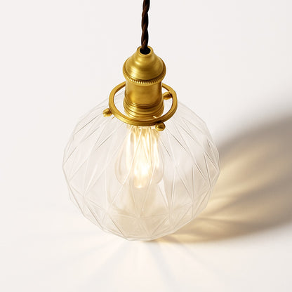 Vue plongeante d’un abat-jour en verre facetté transparent avec ampoule LED et monture en laiton vintage