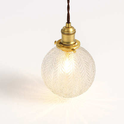 Suspension abat-jour boule en verre nervuré, motif feuille sculptée, éclairage chaleureux pour déco vintage.