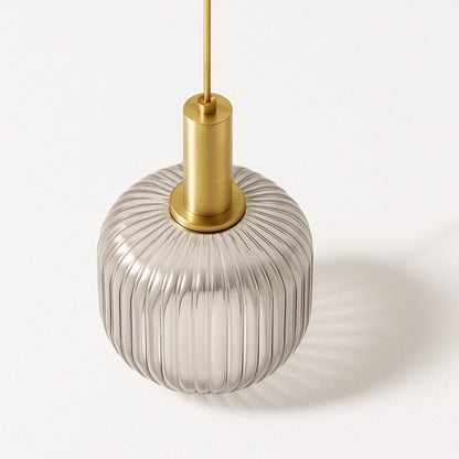 Vue en plongée d’un abat-jour suspension en verre nervuré fumé avec douille dorée satinée sur fond blanc.