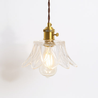 Suspension en verre transparent ondulé avec douille dorée, abat jour élégant pour intérieur raffiné.