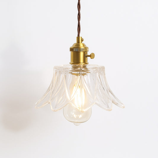 Suspension en verre transparent ondulé avec douille dorée, abat jour élégant pour intérieur raffiné.