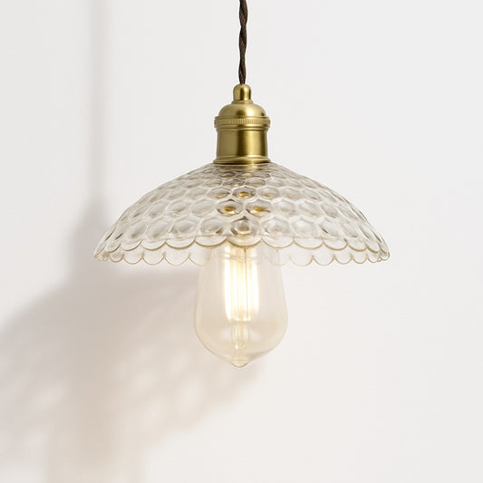 Suspension en verre transparent à reliefs ronds, bord festonné, douille laiton doré, design élégant et rétro.