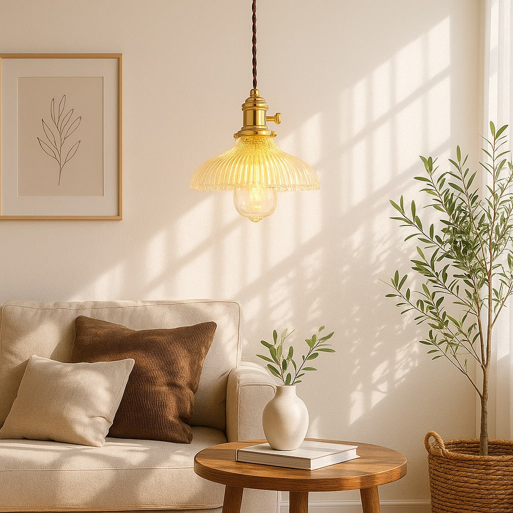 Abat-jour en verre suspendu doré, suspension élégante diffusant une lumière douce dans un salon moderne.