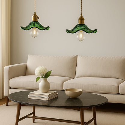 Abat-jour verre vert en suspension dans un séjour moderne, duo d’abat-jour suspension au-dessus d’un canapé beige.