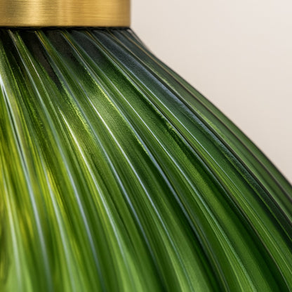 Gros plan sur un abat-jour verre vert d’une suspension design, texture ondulée d’un abat-jour suspension en verre.