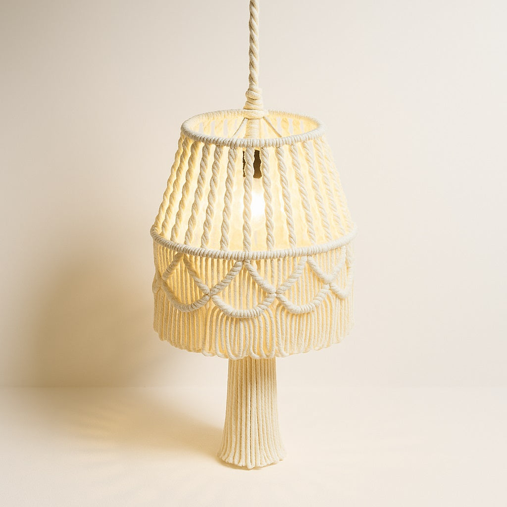Abat-jour blanc en coton tressé avec pampille centrale, en macramé, capté sous lumière douce sur fond neutre.