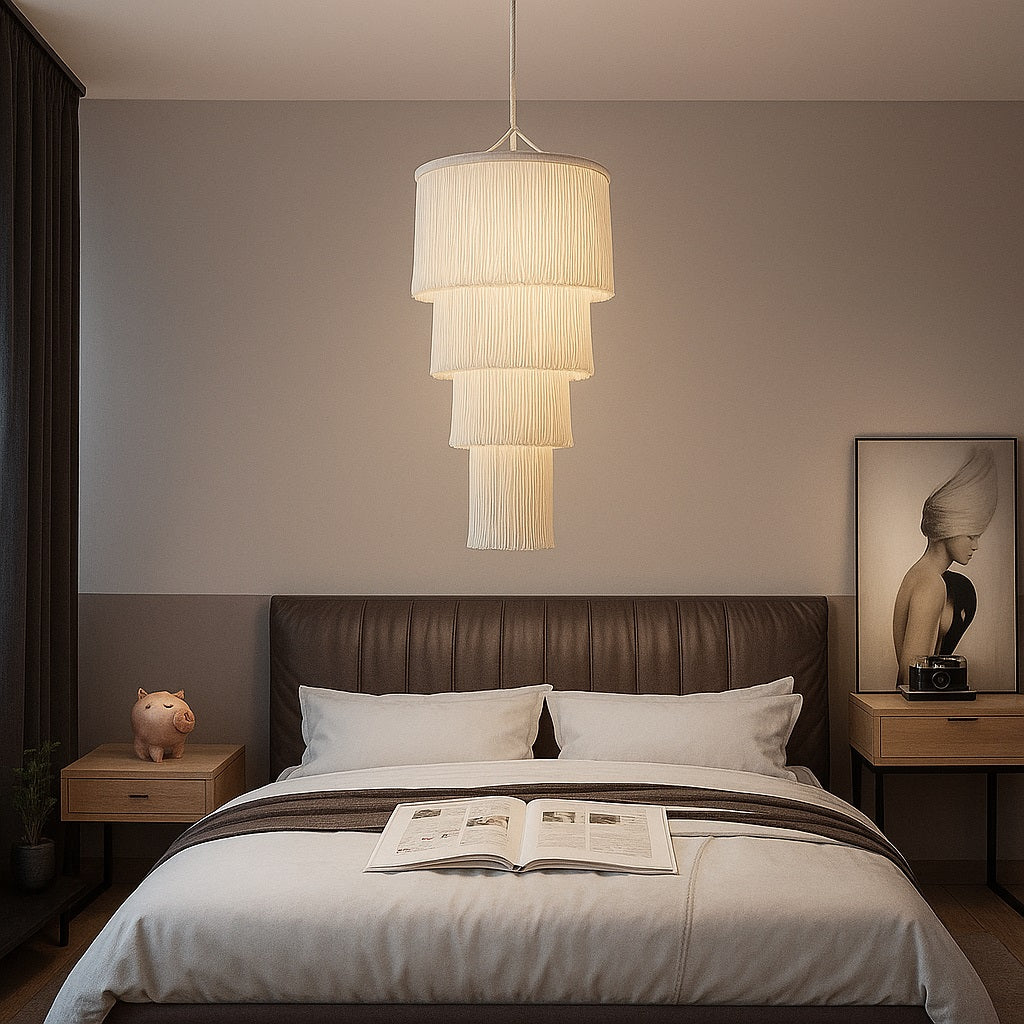 Suspension en coton blanc Lumae dans une chambre, design élégant à franges pour une lumière douce et tamisée.