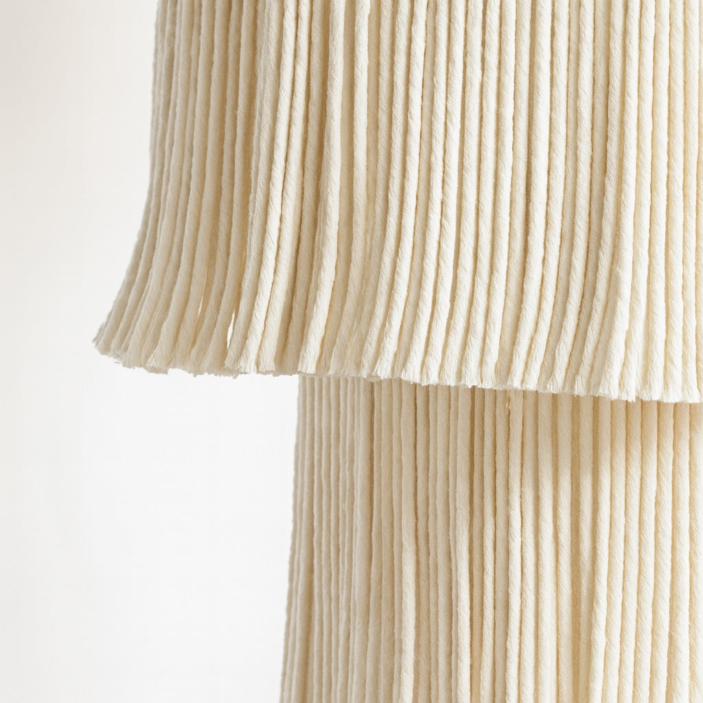 Zoom sur un abat-jour suspension en macramé beige, texture détaillée et fibres tressées en gros plan.