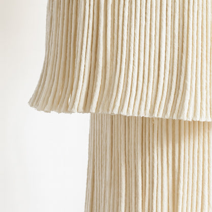Zoom sur un abat-jour suspension en macramé beige, texture détaillée et fibres tressées en gros plan.