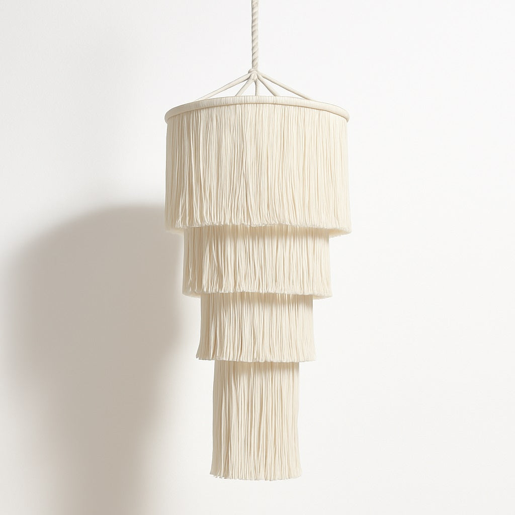 Suspension blanche Lumae en coton à franges longues, au design vertical élégant pour un éclairage doux et décoratif.