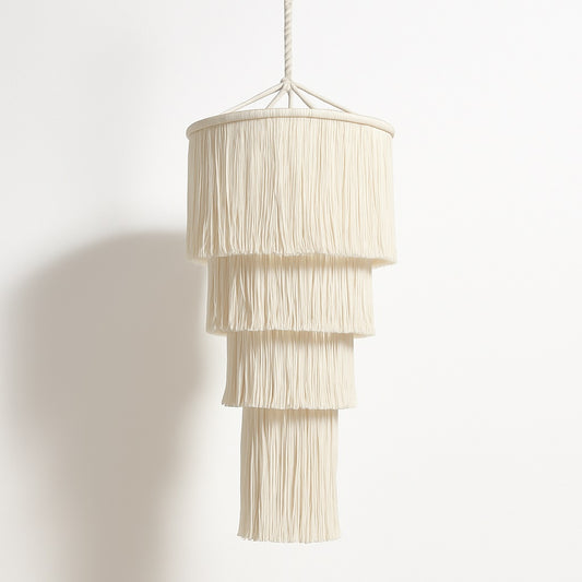 Suspension blanche Lumae en coton à franges longues, au design vertical élégant pour un éclairage doux et décoratif.