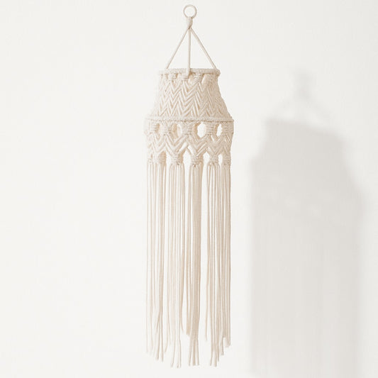 Suspension blanche en coton macramé avec longues franges tombantes, effet graphique et bohème sur fond blanc.