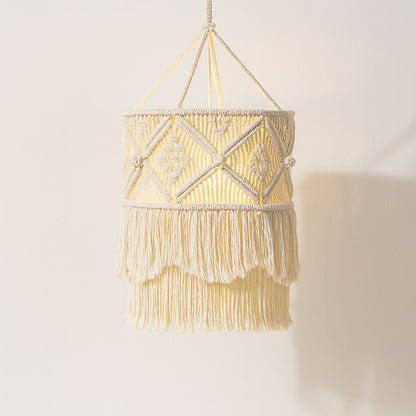 Suspension en coton blanc à franges, abat-jour bohème avec tissage géométrique et lumière douce sur fond neutre.