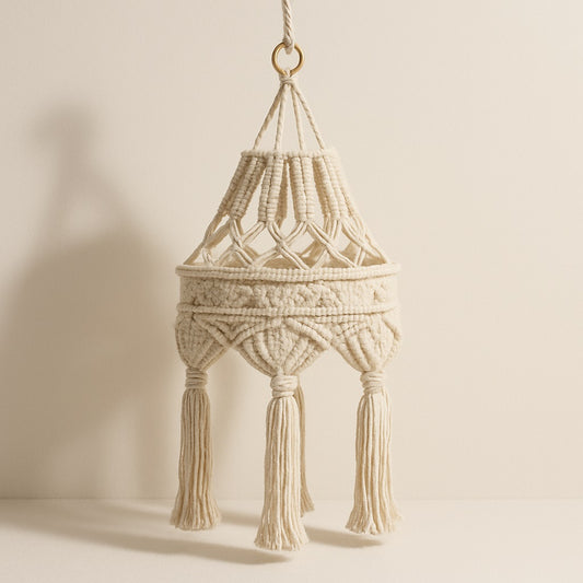 Suspension en coton blanc tressé avec pampilles, abat-jour en macramé naturel au style bohème et ajouré, sur fond beige clair.