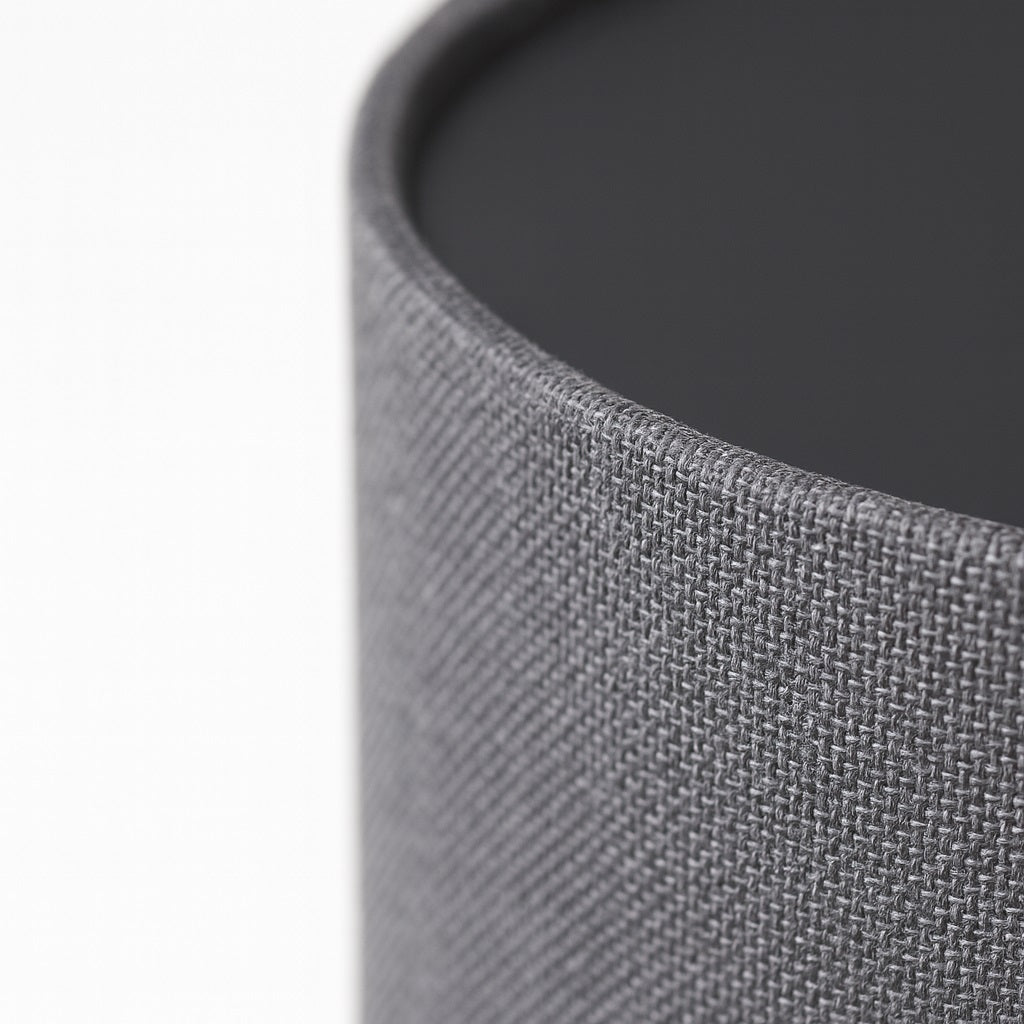 Abat-jour gris foncé en tissu texturé, gros plan détaillé du rebord pour mettre en valeur la qualité du tissu.