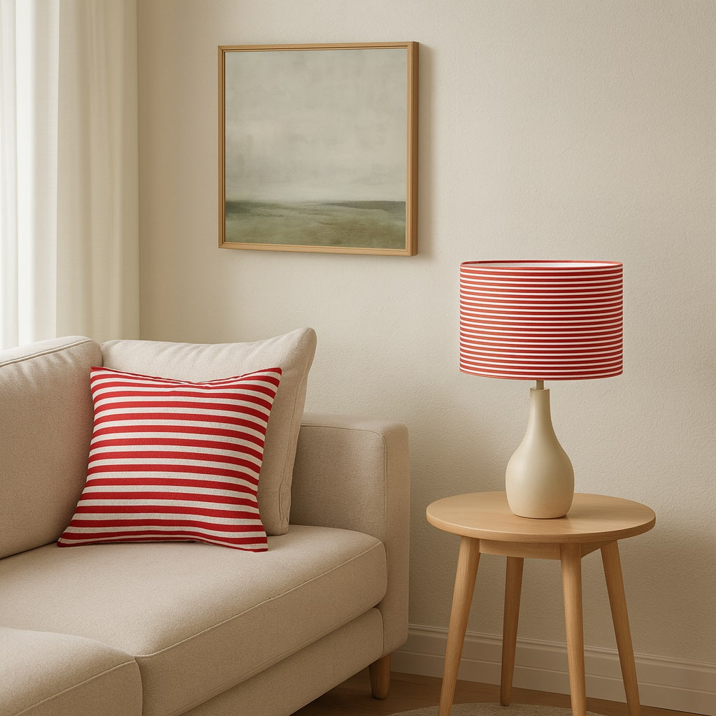 Abat-jour rayé rouge et blanc sur lampe de table, assorti au coussin, idéal pour lampadaire ou déco moderne.