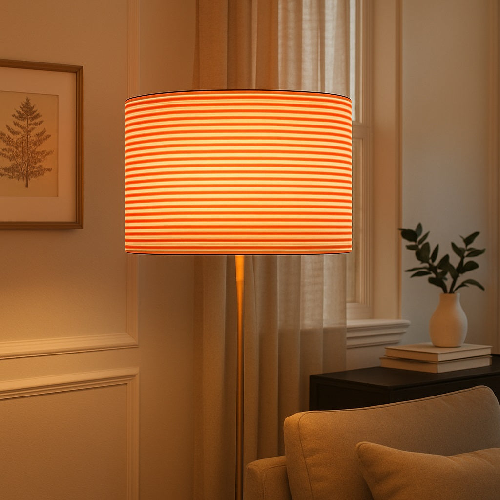 Lampadaire avec abat-jour rayé rouge et blanc diffusant une lumière chaleureuse dans un salon élégant.