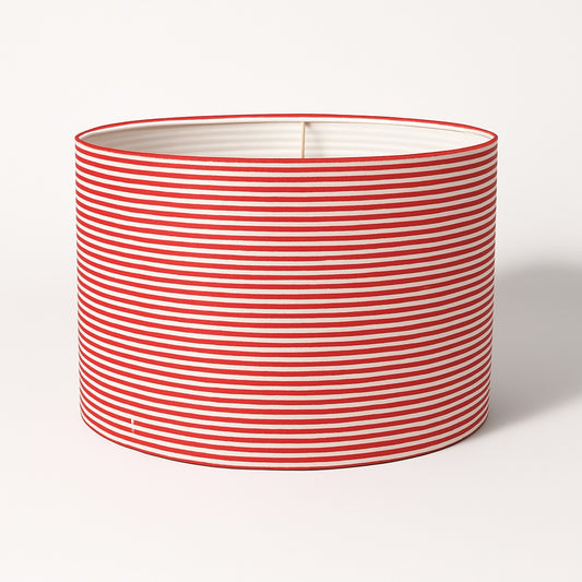 Abat-jour cylindrique rayé rouge et blanc sur fond blanc, parfait pour lampe de salon ou lampadaire.