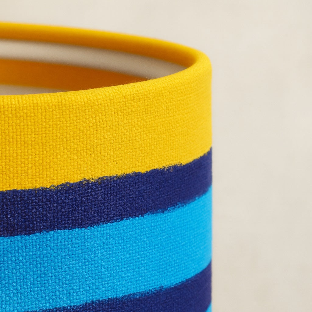 Zoom sur la texture en tissu de l’abat-jour multicolore pour lampadaire, détails de couture et couleurs vives.