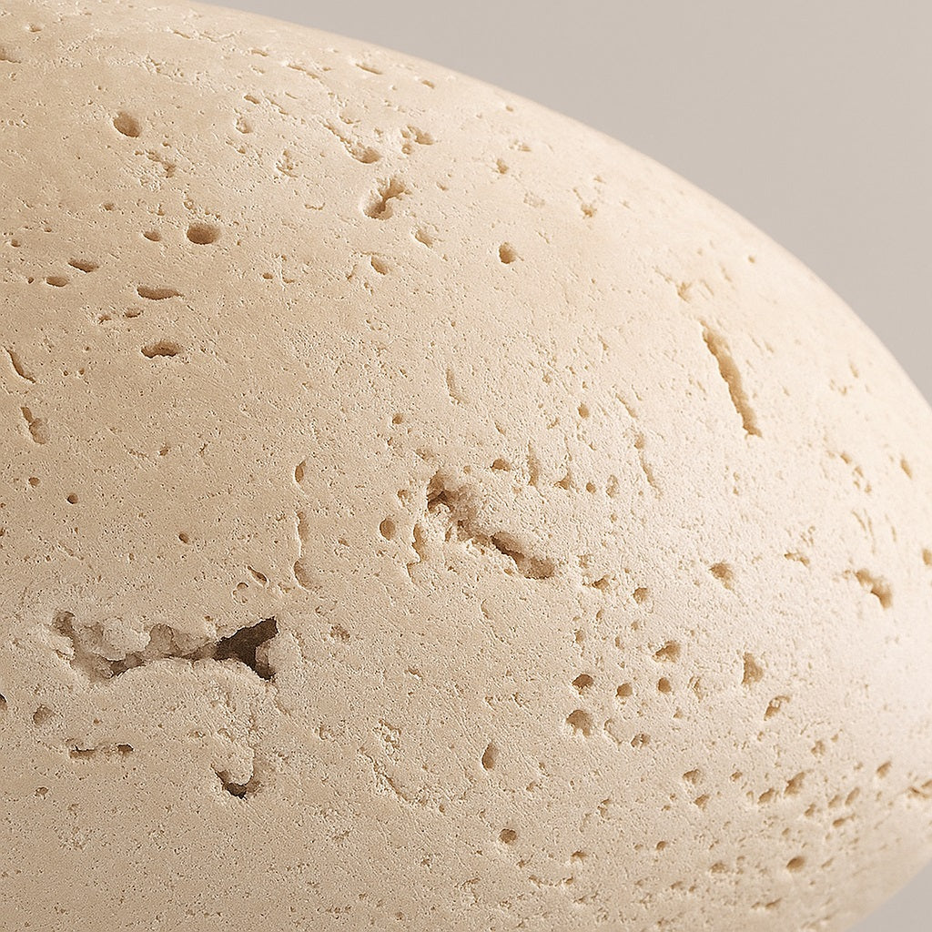 Zoom sur la texture brute d’un abat-jour en travertin naturel, matériau noble pour suspension design et durable.